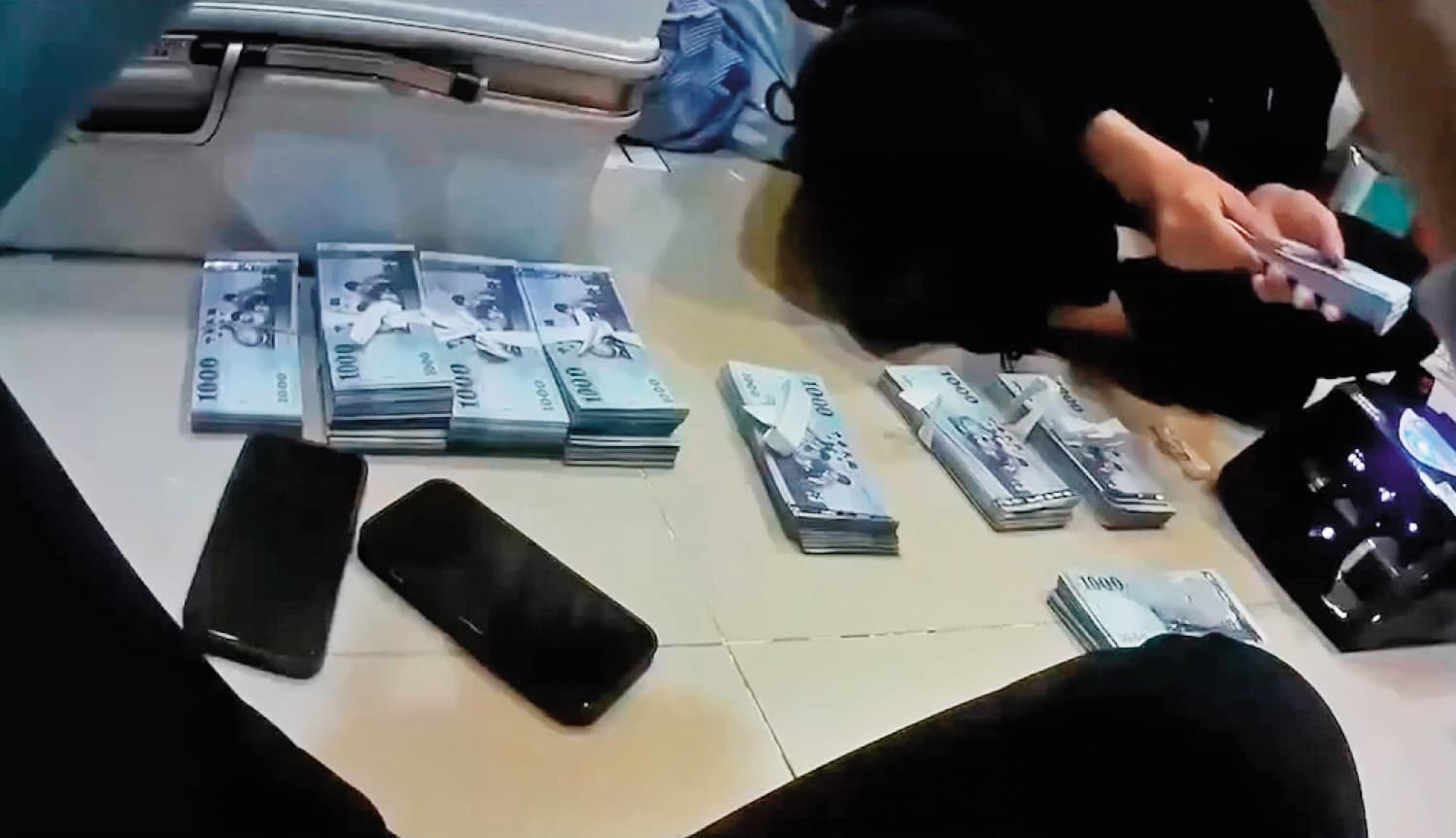 警方到李女在台中承租的小豪宅搜索，於保險箱查扣300多萬元贓款及提款卡等證物。（翻攝畫面）