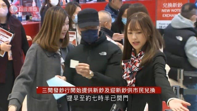 女銀行員引導民眾排隊換新鈔（翻自《香港01》）