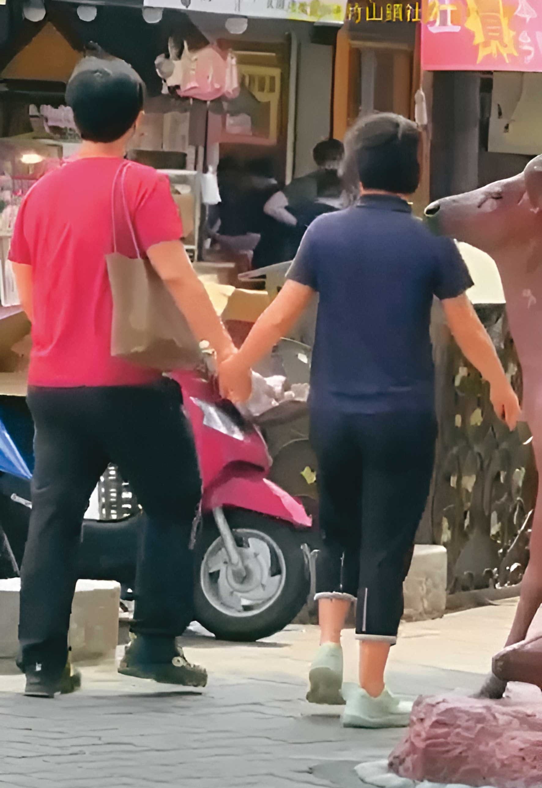 已婚政風主任L男（左）與法官助理K女（右）被直擊當街牽手。（讀者提供）