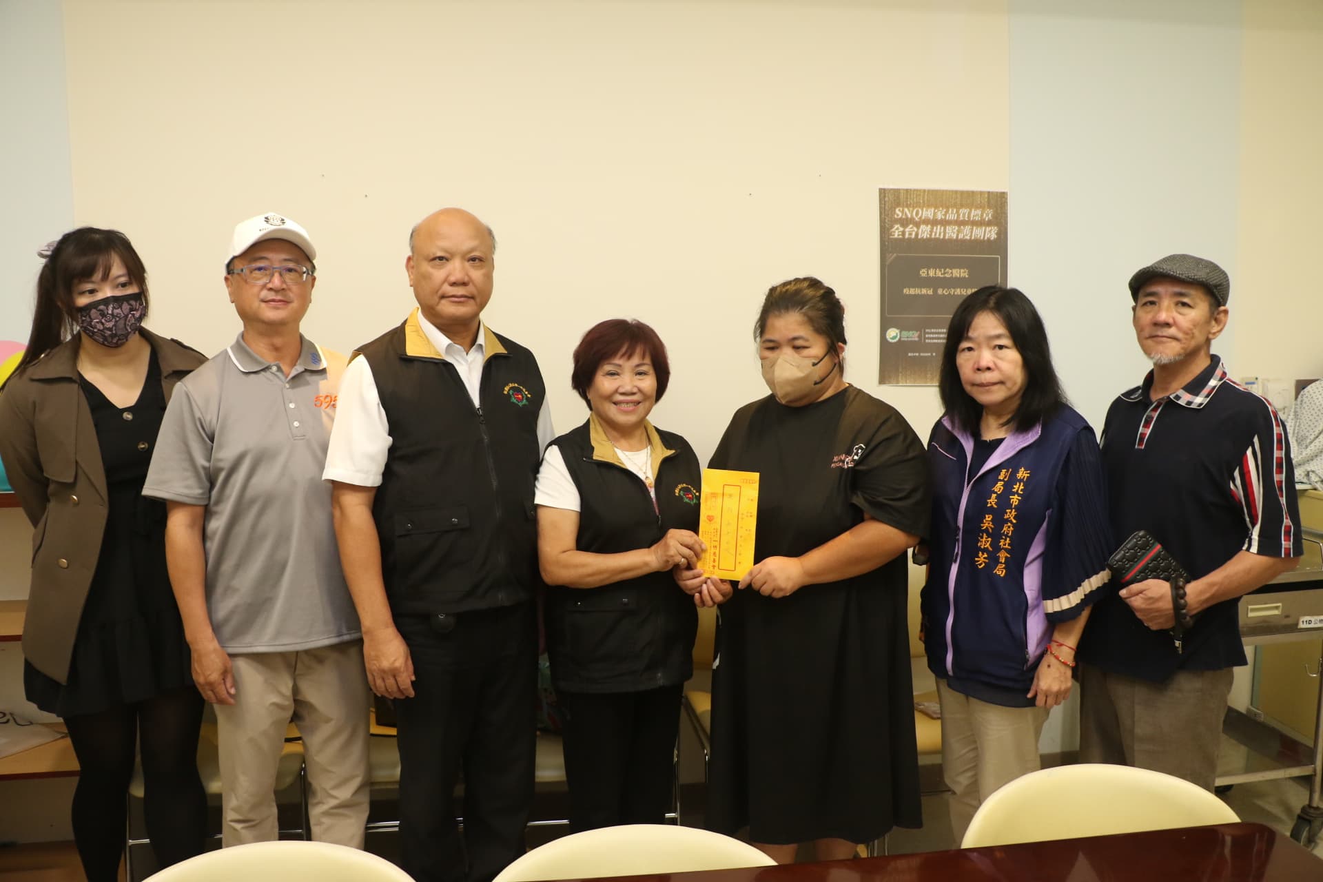 中華單協理事長潘承揚（右起）、社會局副局長吳淑芳、吳媽媽、一竹慈善會理事長許品、圓融行善團團長許誥、急難救助會理事長洪守坿和祕書鄭子妤等人一起到醫院探視吳媽媽，並贈急難救助金。（新北市社會局提供）