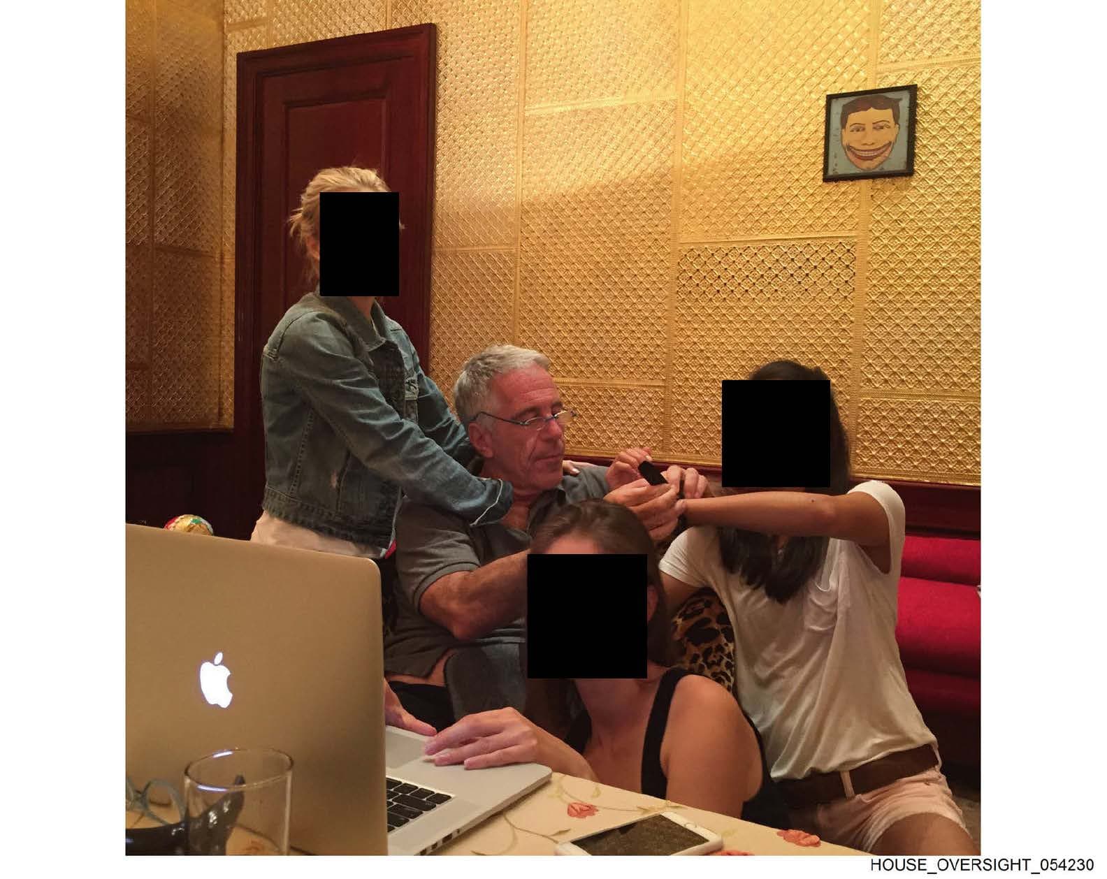 艾普斯坦與多名女子合影，她們的臉部被遮蔽、身分不明。（翻攝House Oversight Committee）