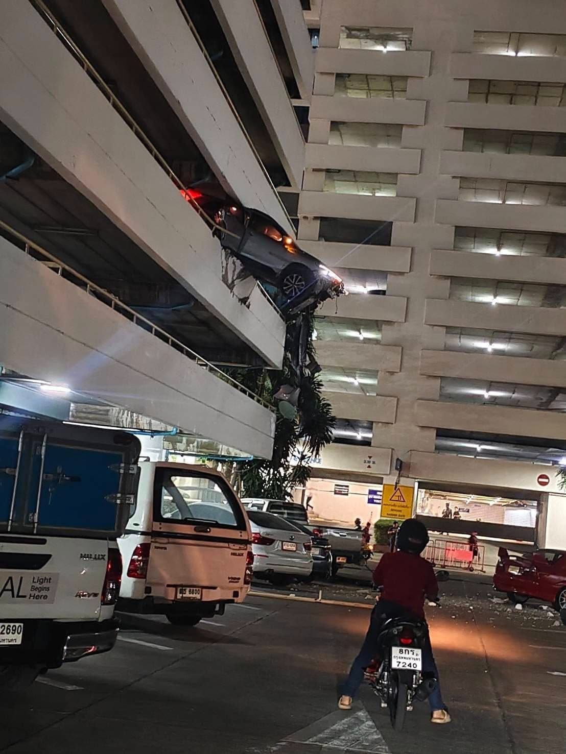 1輛休旅車失控衝破外牆，車頭懸空掛在樓層邊緣，整輛車搖搖欲墜。（翻攝自Sittipon Benz FB）