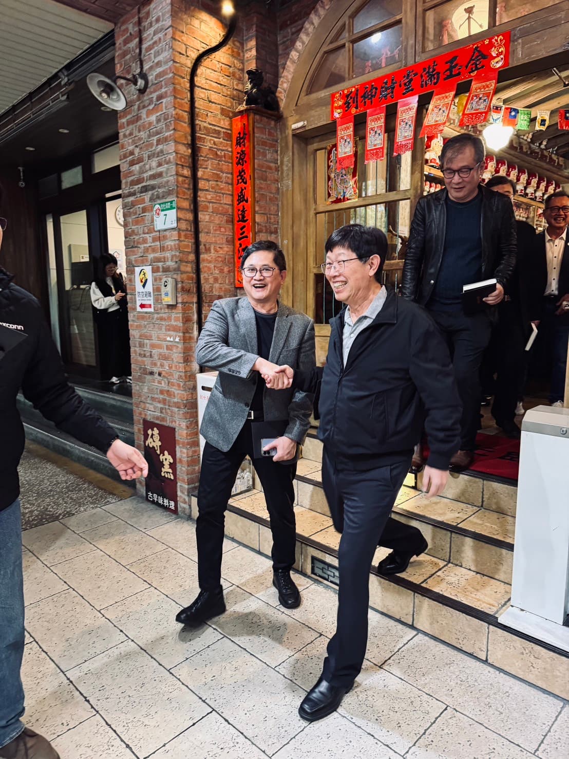 童子賢與劉揚偉連袂步出餐廳，留下握手合影。