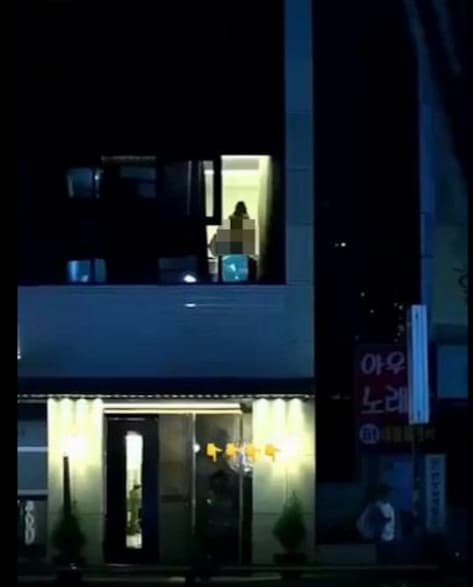 一對男女在窗邊激情愛愛，室內燈光全亮，從窗外可清晰看見火辣春光。（翻攝影片）