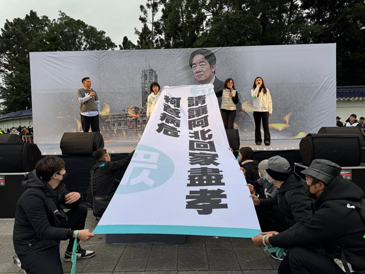 柯美蘭與陳佩琪舉起布條齊喊「柯爸病危，請讓阿北回家盡孝」。