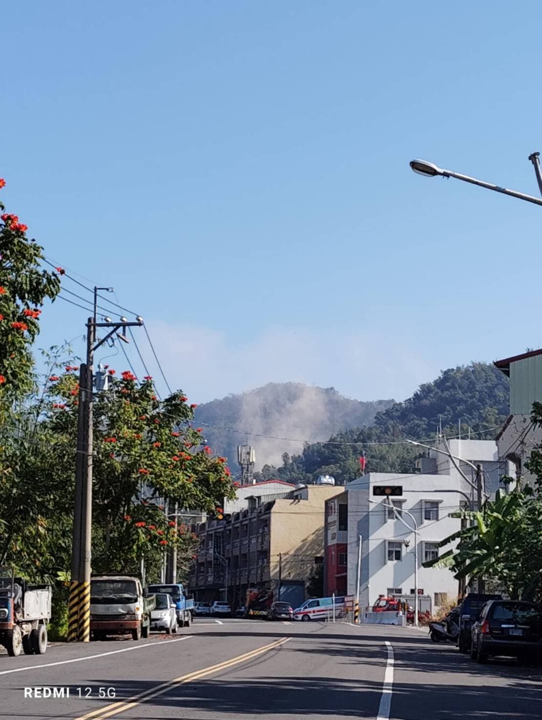 大埔市區土石滑落，遠處可見煙霧。（讀者提供）