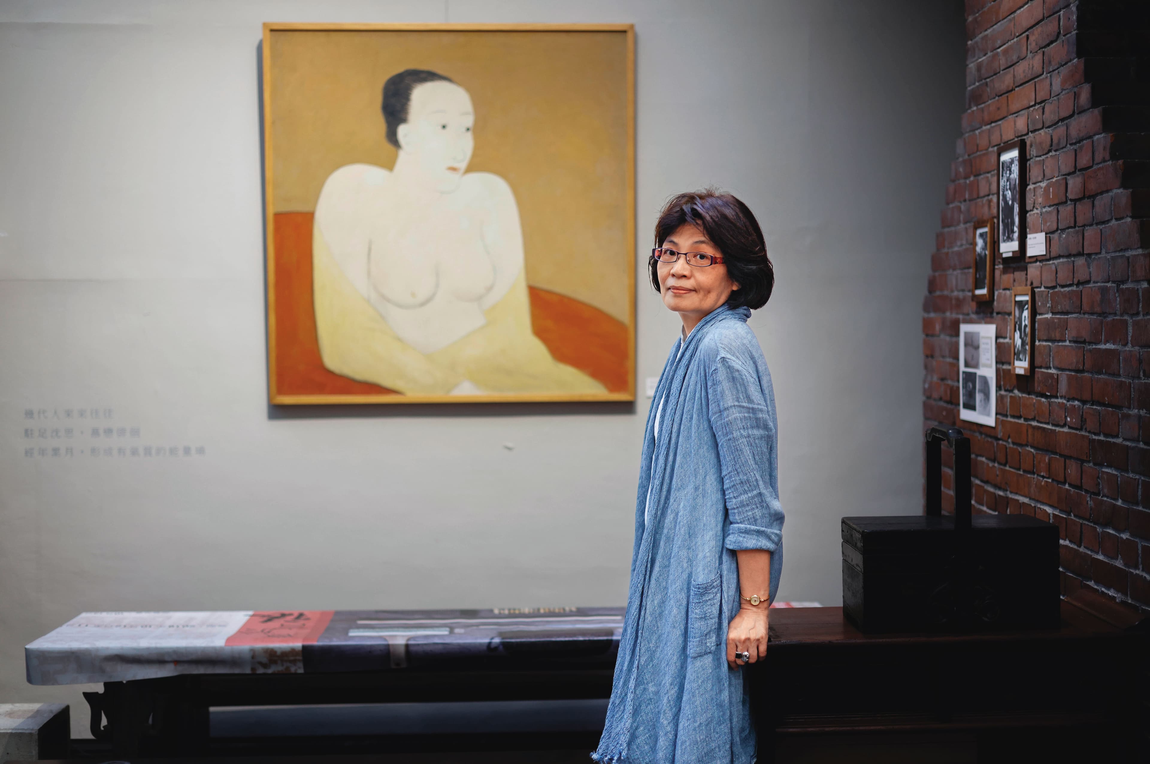 紫藤廬負責人林慧峯。後方是畫家老友邱亞才留給紫藤廬的作品〈仕女〉。