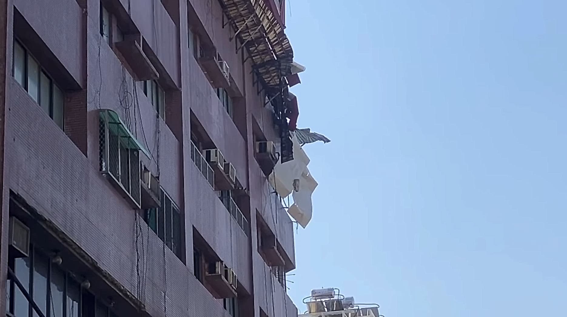 大樓外牆鐵皮搖搖欲墜。（翻攝記者爆料網）