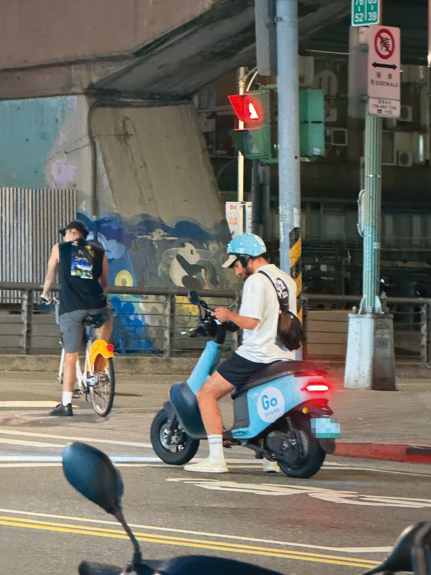 酷被民眾目擊在台北市街頭違規，騎車滑手機。（讀者提供）