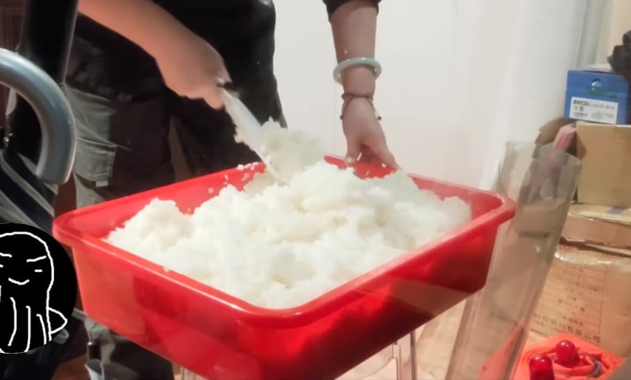 廚師用塑膠桶拌醋飯,旁邊還堆置雜物,被網友指出作法不專業,有食安疑慮。(翻攝YT頻道「蝦土豆」)