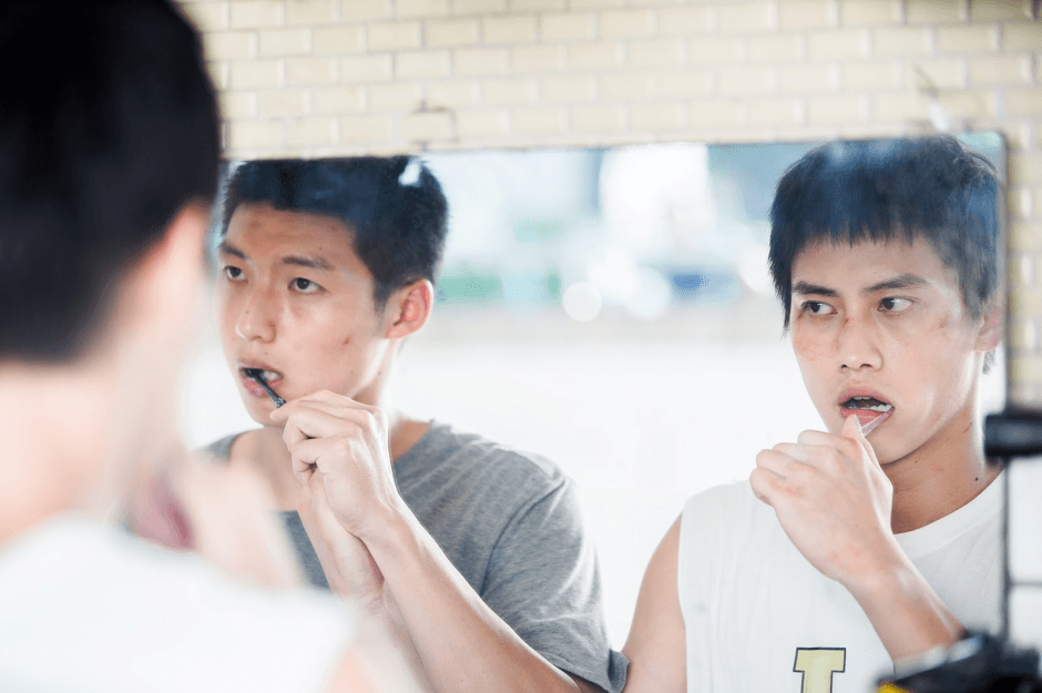 片中處罰球員的方式之一是要求兩人牽手、長時間一起行動,刷牙時也要手牽手。(下半場電影提供)
